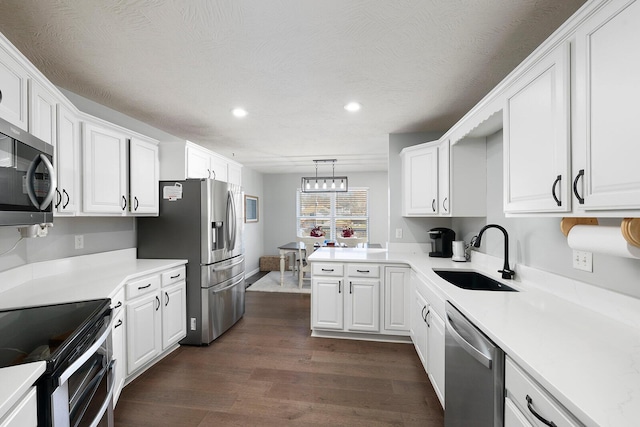 kitchen with pendant lighting, sink, white cabinets, dark hardwood / wood-style flooring, and stainless steel appliances