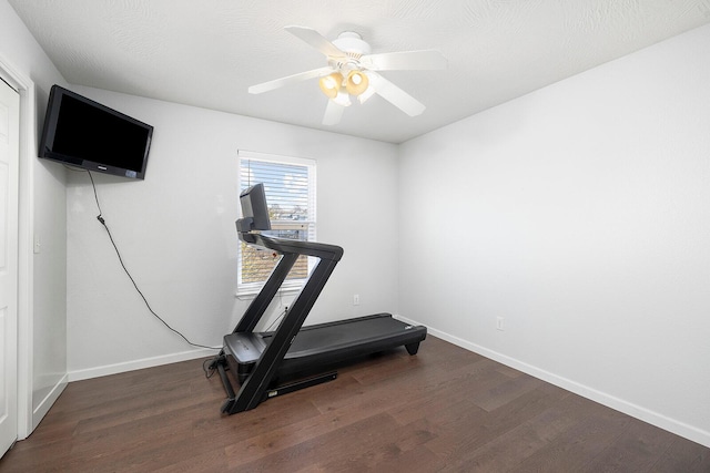 workout area with ceiling fan, a textured ceiling, and dark hardwood / wood-style flooring