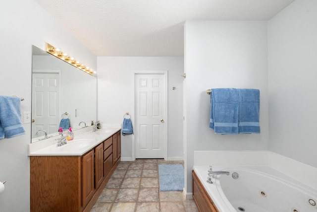 bathroom with a washtub, vanity, and a textured ceiling