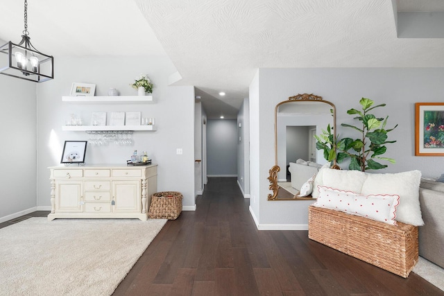 hall featuring a chandelier, hardwood / wood-style floors, and a textured ceiling