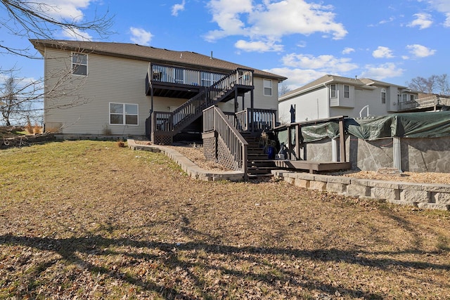 back of house featuring a wooden deck and a lawn