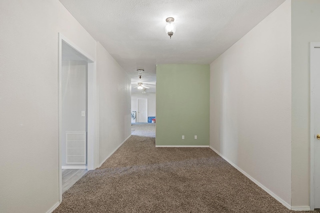 hallway with carpet and a textured ceiling