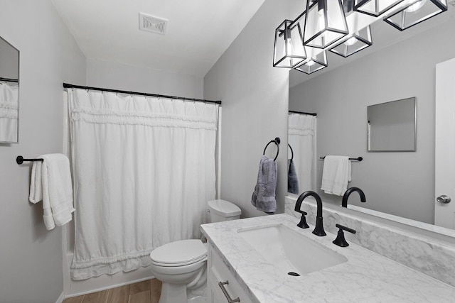 full bathroom featuring wood-type flooring, vanity, a notable chandelier, toilet, and shower / bath combo