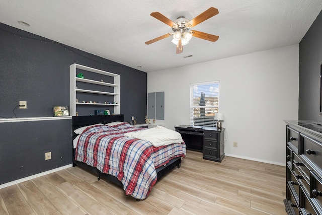 bedroom featuring ceiling fan, light hardwood / wood-style floors, and a textured ceiling