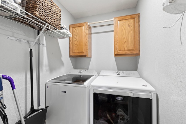 laundry area with washer and clothes dryer and cabinets