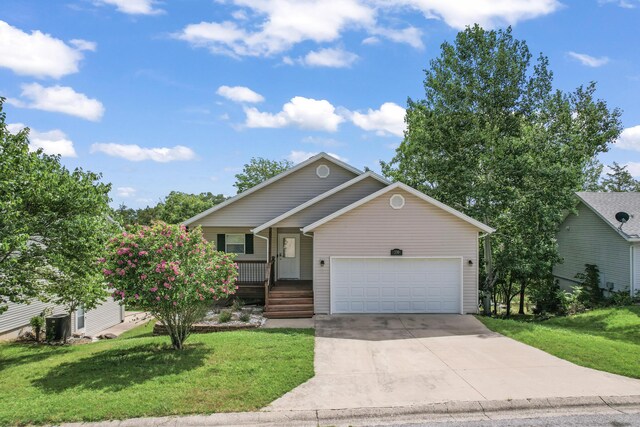 view of front of property featuring a garage, a front yard, and covered porch