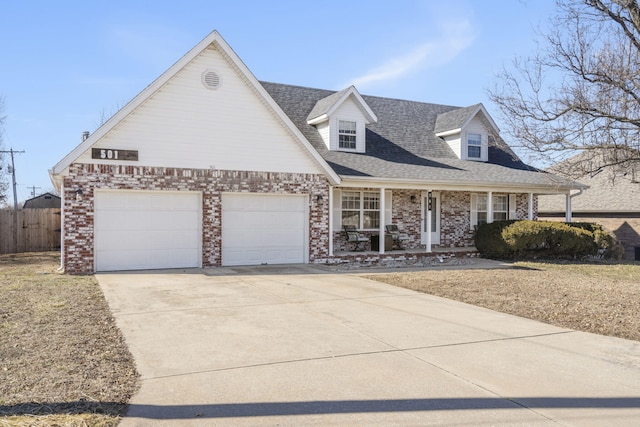 new england style home with a garage and covered porch