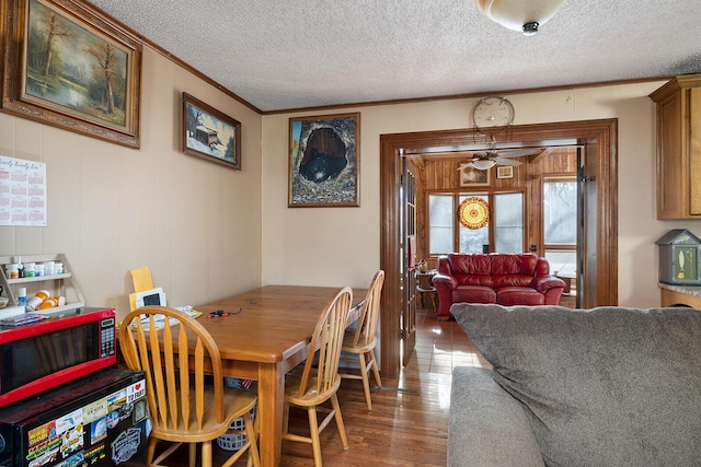 dining area featuring crown molding, hardwood / wood-style floors, and a textured ceiling