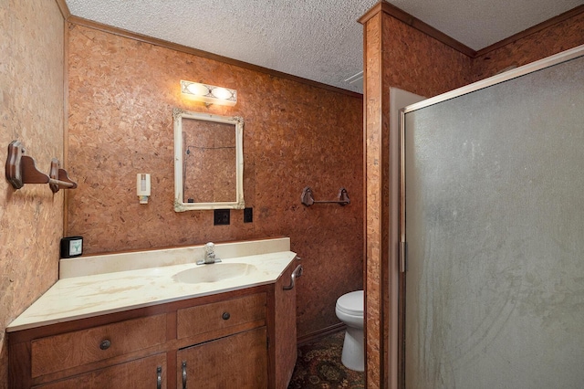 bathroom with toilet, a textured ceiling, ornamental molding, vanity, and a shower with door