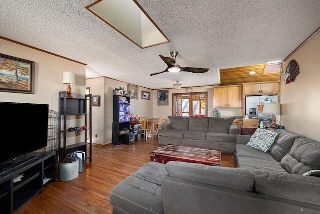 living room featuring crown molding, dark wood-type flooring, a textured ceiling, and ceiling fan