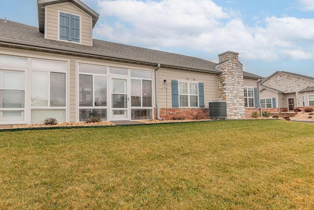 rear view of house with a yard and central AC