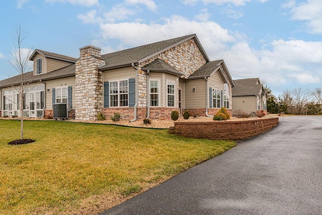 view of side of property with cooling unit and a lawn