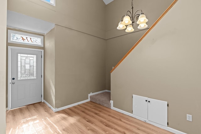 foyer entrance with an inviting chandelier and light hardwood / wood-style floors