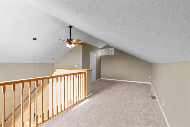 bonus room with ceiling fan, light colored carpet, vaulted ceiling, and a textured ceiling