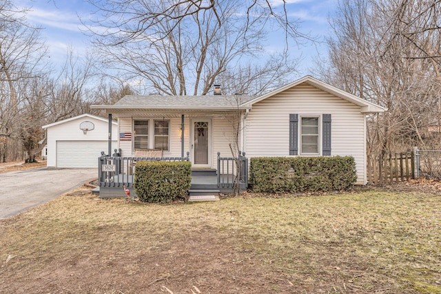 single story home featuring a garage, an outdoor structure, a front yard, and a porch