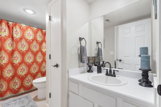 bathroom featuring tile patterned floors, toilet, and vanity