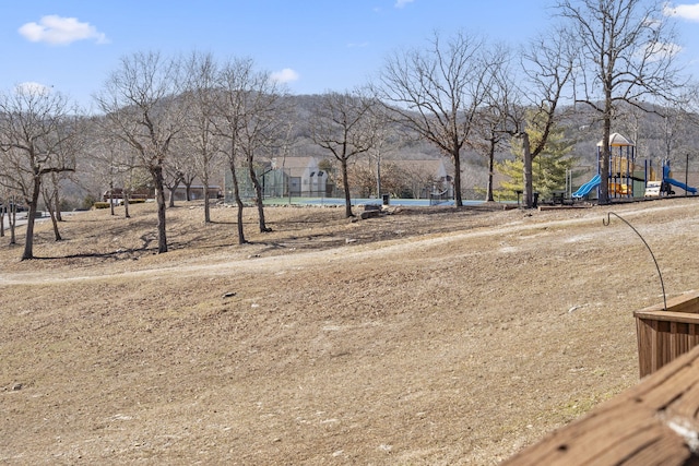 view of yard featuring a playground and a mountain view