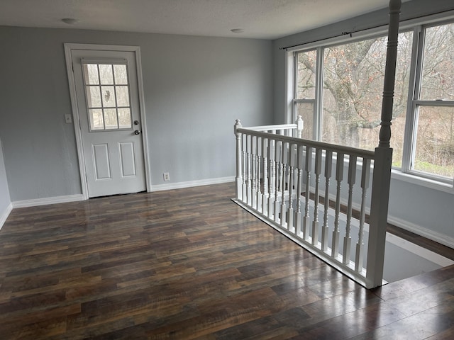 entrance foyer with dark hardwood / wood-style floors and a textured ceiling