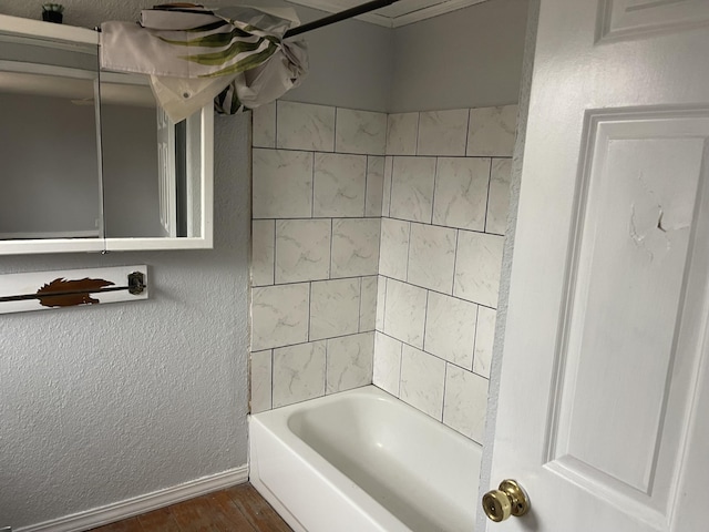 bathroom featuring hardwood / wood-style flooring and tiled shower / bath