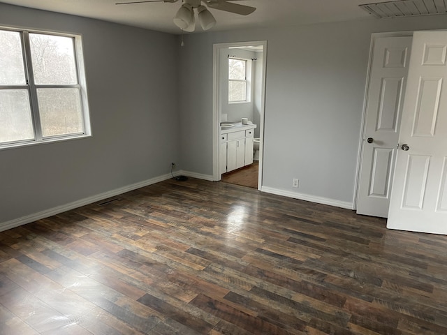 unfurnished bedroom with ensuite bath and dark hardwood / wood-style floors