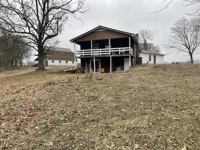 rear view of house featuring a yard and central AC unit