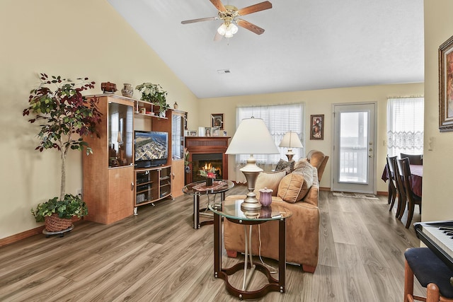 living room featuring wood-type flooring, vaulted ceiling, and ceiling fan