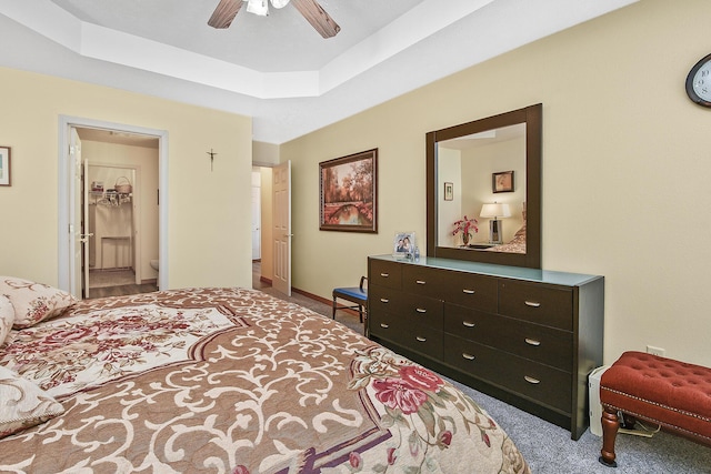 bedroom with ceiling fan, carpet flooring, and a tray ceiling