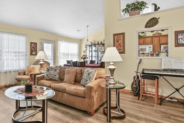 living room with lofted ceiling and light hardwood / wood-style flooring