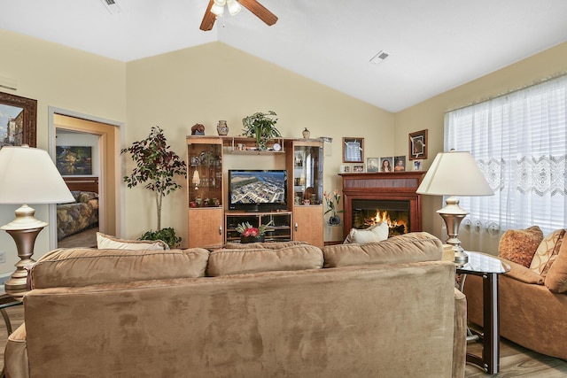 living room featuring ceiling fan and lofted ceiling