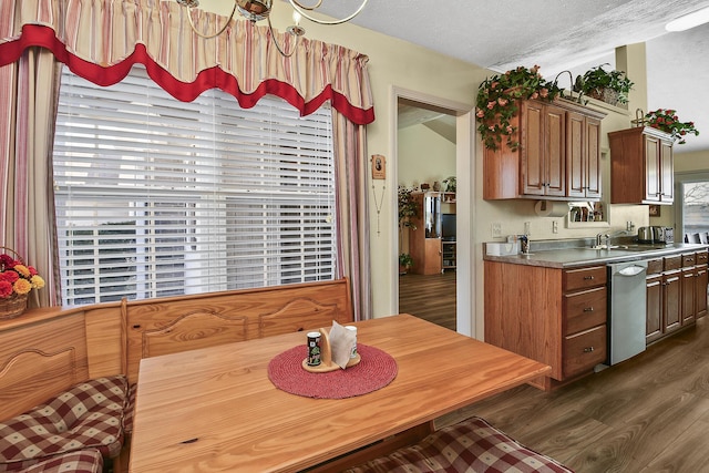 kitchen featuring sink, a textured ceiling, dark hardwood / wood-style flooring, dishwasher, and breakfast area