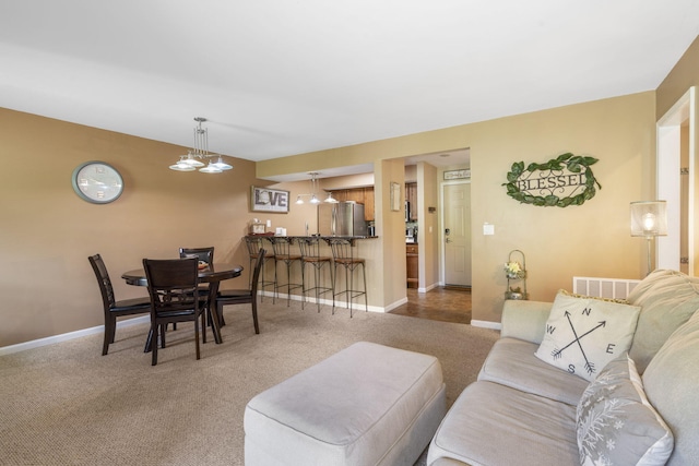 living room featuring a notable chandelier and carpet