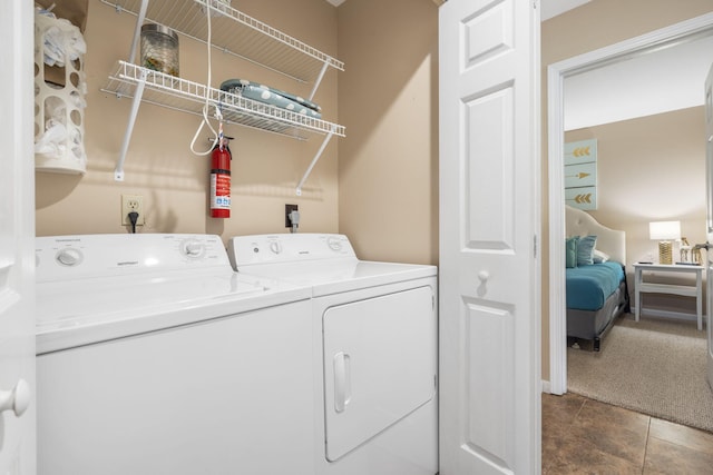 clothes washing area with washing machine and clothes dryer and carpet floors