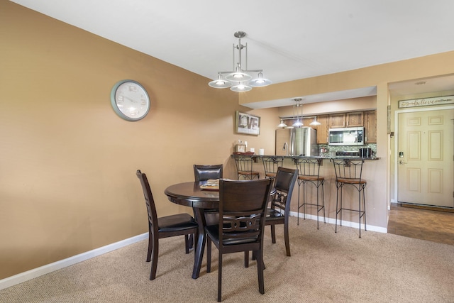 dining area featuring light colored carpet and an inviting chandelier