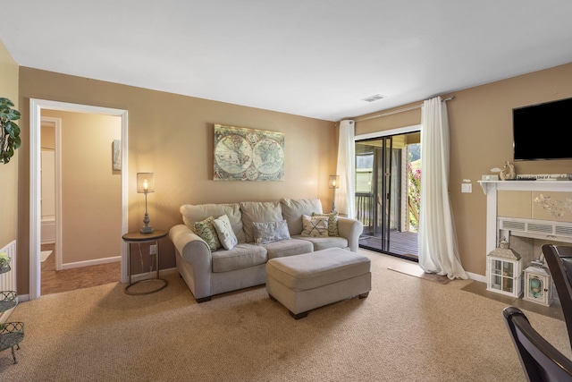 living room featuring a tile fireplace and carpet