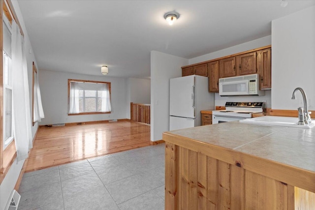 kitchen featuring sink, white appliances, and light tile patterned floors