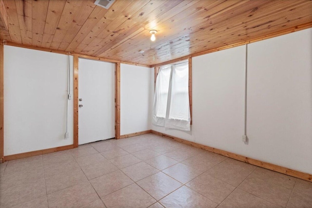 unfurnished room with light tile patterned floors and wood ceiling