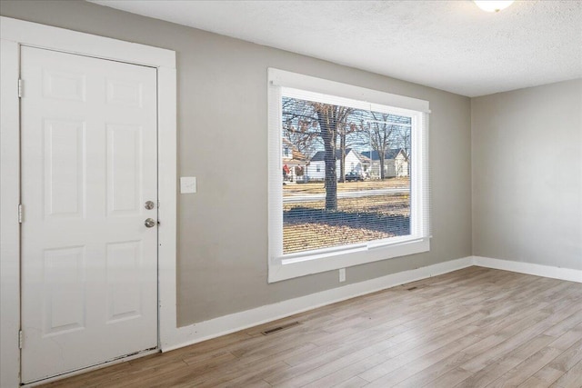 entrance foyer with a textured ceiling and light wood-type flooring