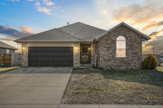 view of front of home with a garage and a lawn