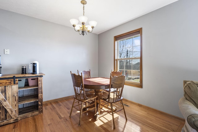 dining area featuring a notable chandelier and light wood-type flooring