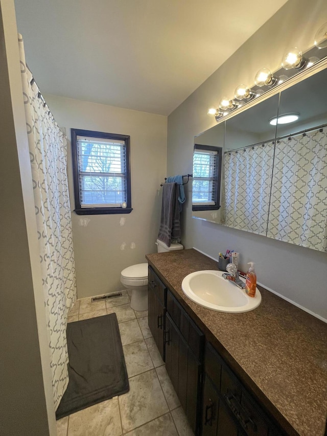 bathroom with vanity, toilet, and tile patterned flooring