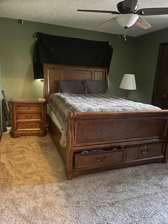 bedroom featuring ceiling fan, light colored carpet, and a textured ceiling