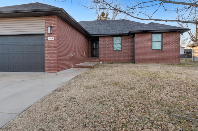 single story home featuring a garage and a front lawn