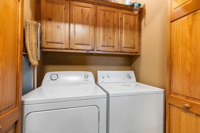 clothes washing area featuring cabinets and independent washer and dryer