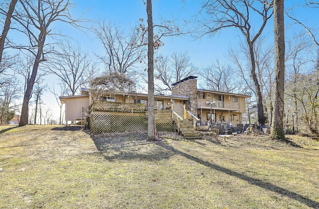 back of house with a lawn, a balcony, and a deck