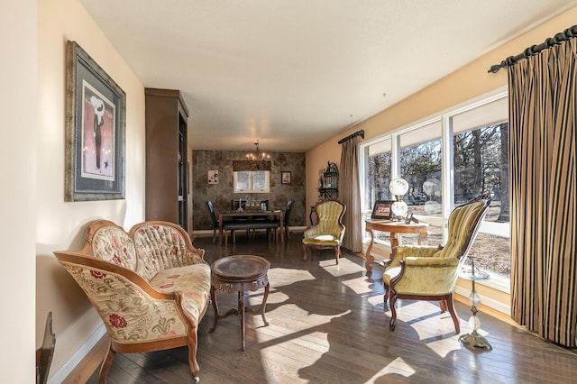 sitting room with a notable chandelier, wood-type flooring, and a wealth of natural light