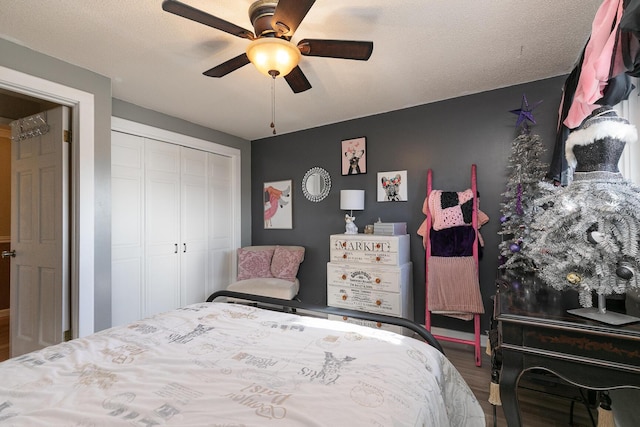 bedroom featuring hardwood / wood-style floors, a textured ceiling, a closet, and ceiling fan