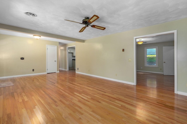 spare room featuring ceiling fan, light hardwood / wood-style flooring, and a textured ceiling