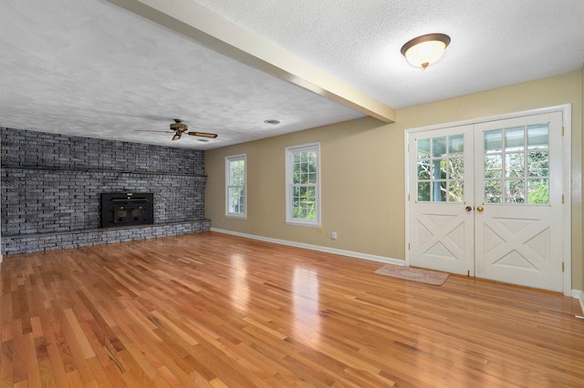 entryway with french doors, ceiling fan, a textured ceiling, beam ceiling, and light hardwood / wood-style flooring