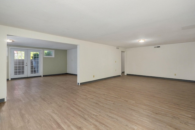 empty room with light hardwood / wood-style flooring and french doors