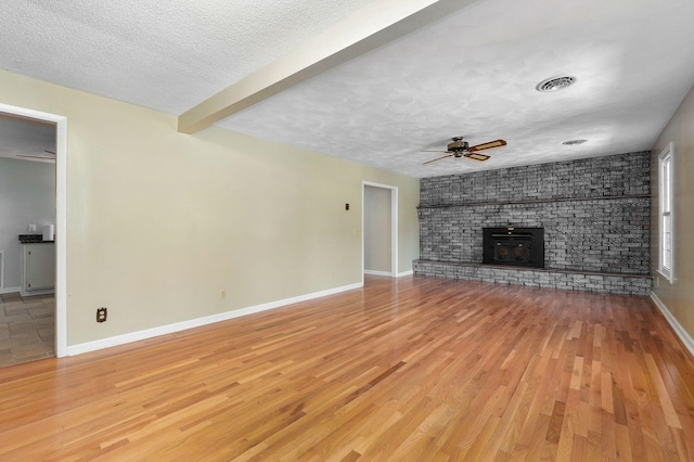 unfurnished living room with ceiling fan, wood-type flooring, and a textured ceiling